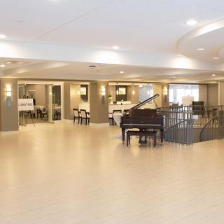 A modern and spacious lobby featuring a grand piano with ample seating.