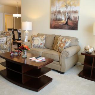 A cozy living room featuring a comfortable sofa, elegant coffee table, decorative lamps, and wall art.