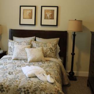 A cozy bedroom with patterned bedding and stylish lamps.