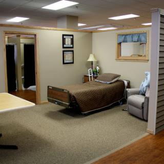 A cozy bedroom setting featuring a brown bed, a comfortable chair, and decorative elements.