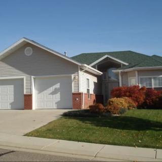 A suburban house with a two-car garage and a well-maintained lawn.