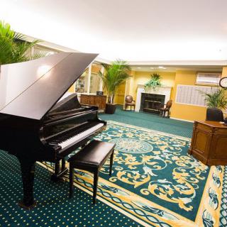 A beautifully decorated music room featuring a grand piano and elegant furnishings.