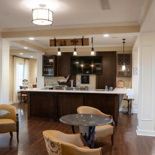 A modern kitchen with dark cabinetry, an island, and a cozy dining area.