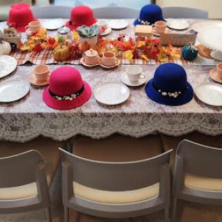 A vibrant autumn-themed table setting adorned with colorful hats and seasonal decorations.