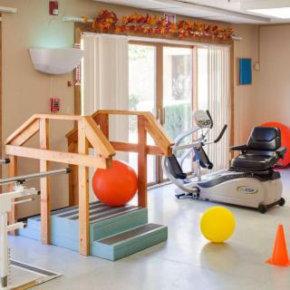A well-equipped physical therapy room with various exercise and rehabilitation equipment.