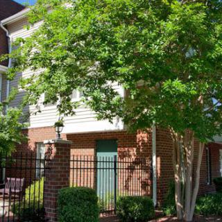 A charming residential home with a brick exterior and surrounding greenery.