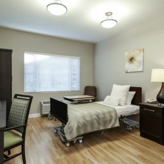 A modern and comfortable hospital room with a single bed and stylish furnishings.