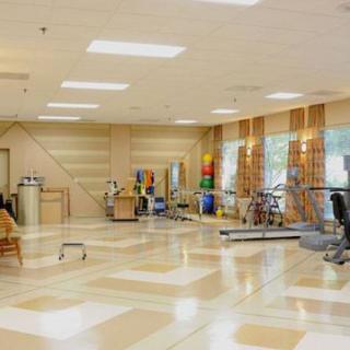 A spacious gym with various exercise equipment and a bright interior.