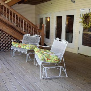 A cozy patio setup with cushioned chairs on a wooden deck.