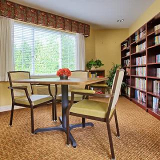 Cozy reading room with bookshelves and a table by the window.
