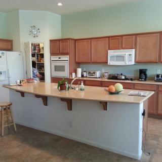 A spacious modern kitchen with wooden cabinets and various appliances.