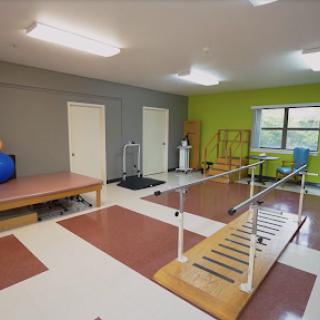 A well-equipped physical therapy room featuring rehabilitation tools and an exercise area.