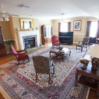 A spacious living room featuring comfortable seating, a cozy fireplace, and a vibrant rug.