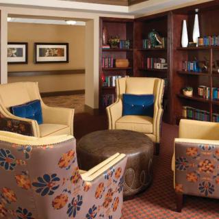 A cozy library seating area with armchairs and bookshelves.