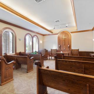 A serene courtroom interior featuring wooden benches and large windows.