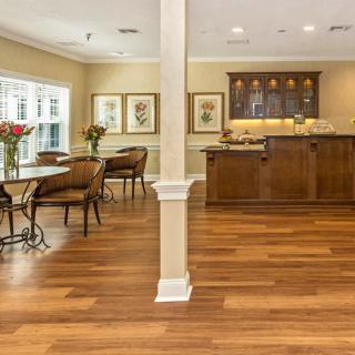 A spacious living and dining area with hardwood floors, natural lighting, and elegant furnishings.