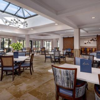 Spacious and elegantly designed restaurant dining area with skylight and comfortable seating.