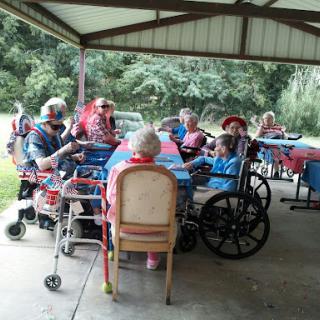 A group of elderly individuals enjoying a social gathering under a covered area.