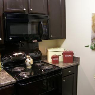 A cozy kitchen corner featuring a stove, microwave, and stylish decor.