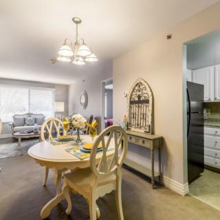 A cozy dining area with a vintage-style table and chairs, adjacent to a living room and kitchen.