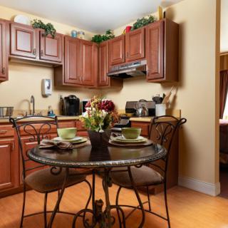 Cozy kitchen with wooden cabinets and a small dining table set for two.