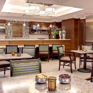 A modern restaurant dining area with a bar and comfortable seating.