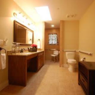A well-lit bathroom interior featuring a sink, mirror, and toilet.