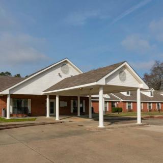 A school building with a covered entrance on a sunny day.