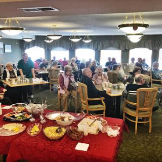 A lively dining event with various food offerings, showcasing a social gathering of individuals enjoying their time together.
