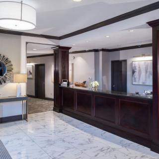 Modern hotel lobby with a marble floor and reception desk.
