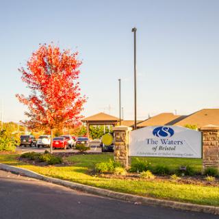 A beautiful autumn scene showcasing vibrant red foliage and a welcoming entrance to a residential community.