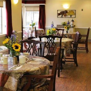 A cozy dining room with tables set and decorated with sunflowers.