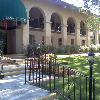 The entrance to a hotel with arched architecture and lush greenery.