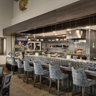 A modern restaurant interior featuring a stylish bar and open kitchen layout.