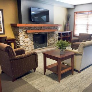 A cozy living room setup featuring a fireplace, comfortable seating, and a television.
