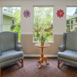 A cozy living room setup with two armchairs and a small table by the windows.