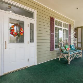 A cozy porch with a bench and a wreath on the door.
