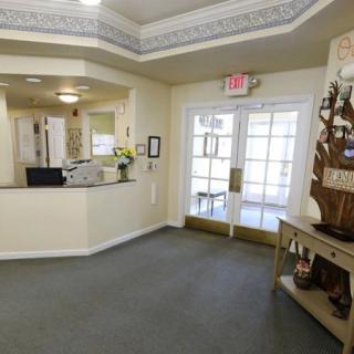 A well-lit lobby area with a reception desk, decorative elements, and a carpeted floor.