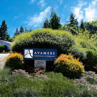 A welcoming sign surrounded by lush greenery and a clear blue sky.