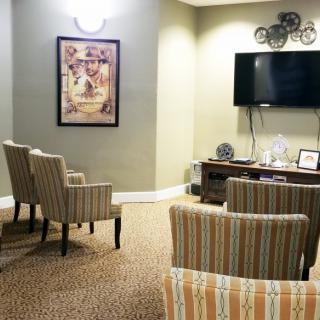 A cozy seating area with striped chairs, a wall-mounted TV, and decorative elements.