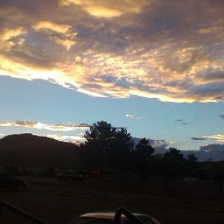 A beautiful sunset painting the sky with vibrant clouds over a mountainous landscape.