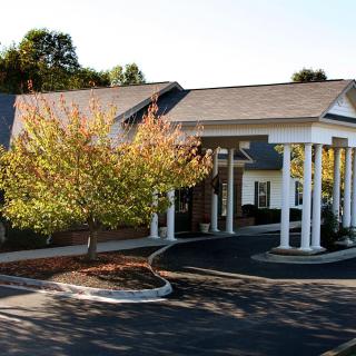 A building with a columned entrance and surrounding trees.