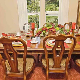 A well-set dining table with elegant wooden chairs and decorative tableware in a cozy dining room.