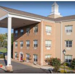 A three-story brick hotel with a covered entrance and large columns.