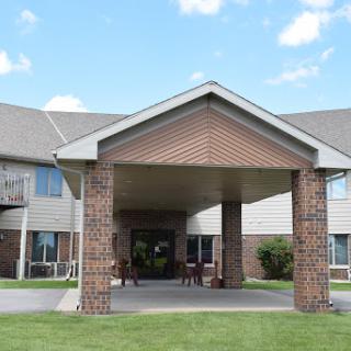 A welcoming entrance to a residential building under a clear blue sky.