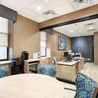 A modern office space featuring a reception area with furniture and natural light.