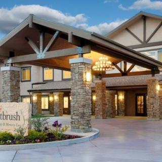 A well-lit building entrance with architectural features and landscaping.