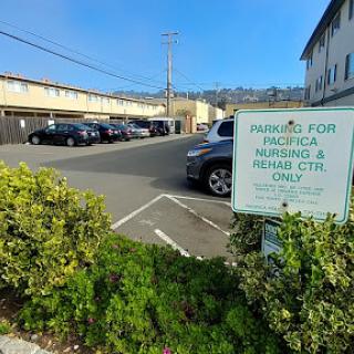 A view of a parking area with a sign indicating it is for Pacifica residents and rental cars only.