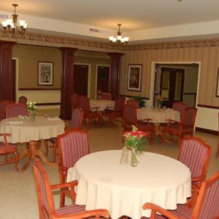 An elegantly decorated dining room with round tables and upholstered chairs.