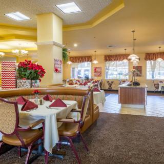 A cozy restaurant interior with neatly arranged tables and chairs, featuring warm lighting and inviting decor.